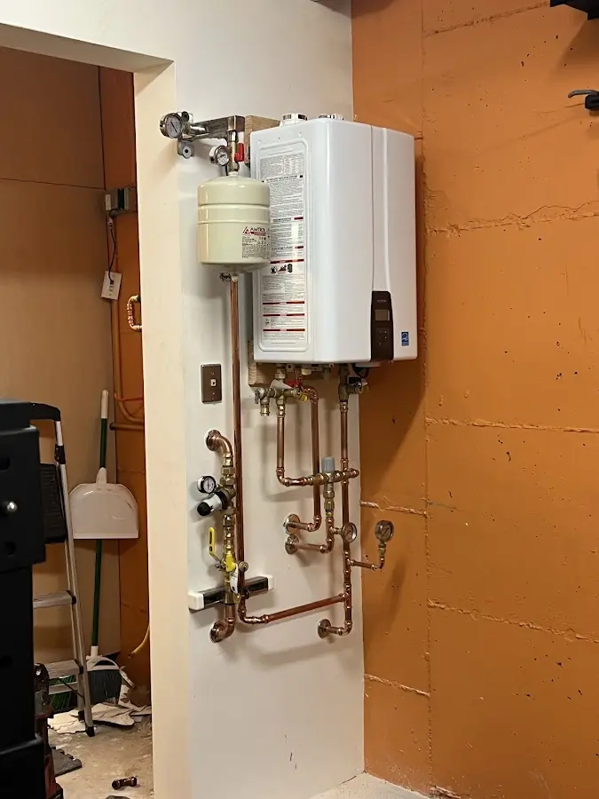 Plumbing technician inspecting water heater connections in Mobridge